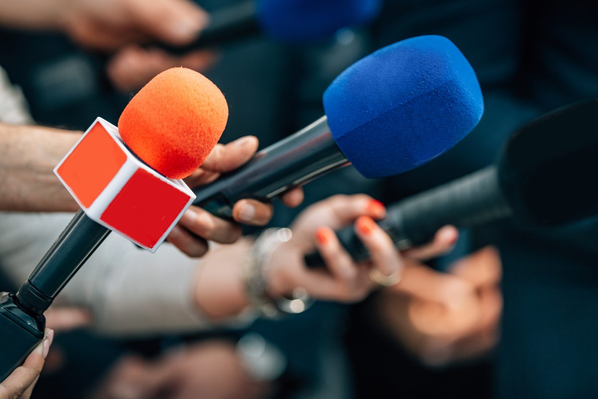 News reporters interviewing a subject about a suicide.