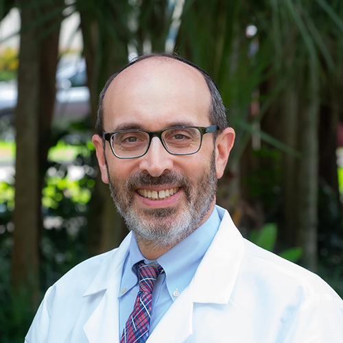 Medical professional in outdoor setting wearing a white lab coat